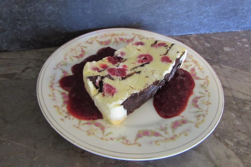 Viennetta dessert on plate with raspberry sauce