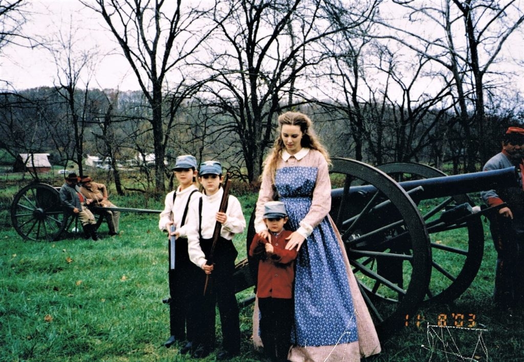 mother and sons in costume at at civil war reenactment schooling