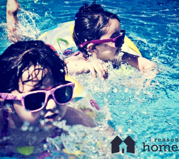 two children in swimming pool on sunny summer day