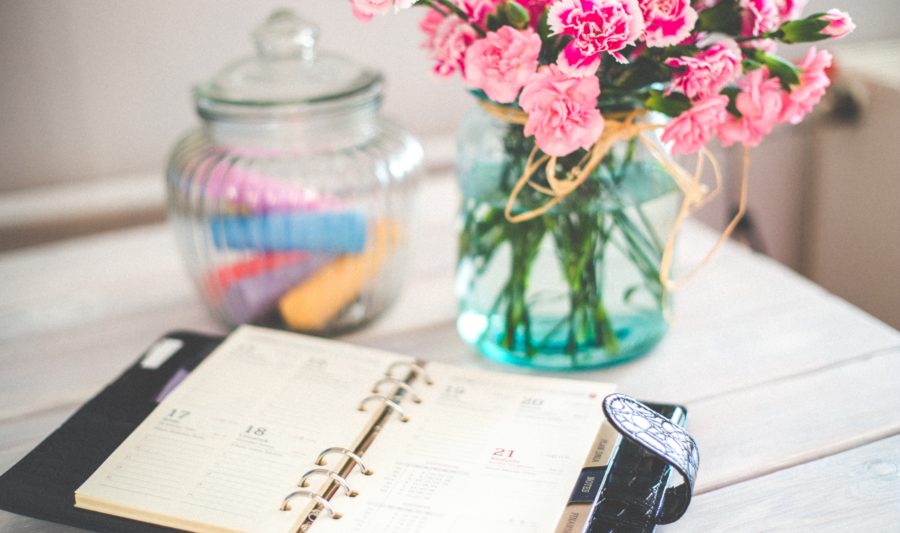 calendar planner on desk with flower arrangement